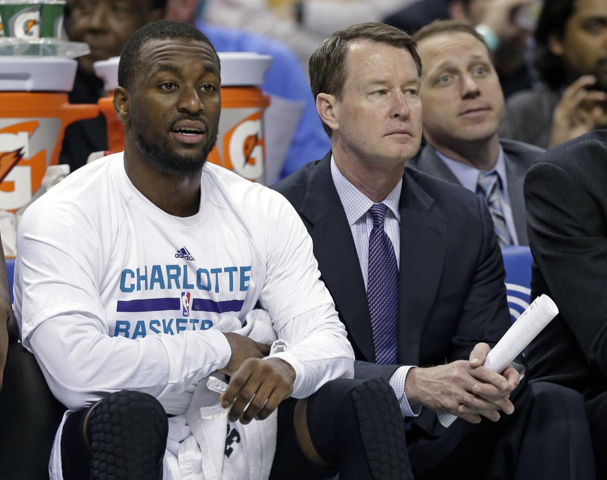 Hornets Assistant Coach Mark Price, right, sits on the bench with guard Kemba Walker during a game Wednesday night. Price has reportedly been hired as the new coach of the Charlotte 49ers college basketball program.