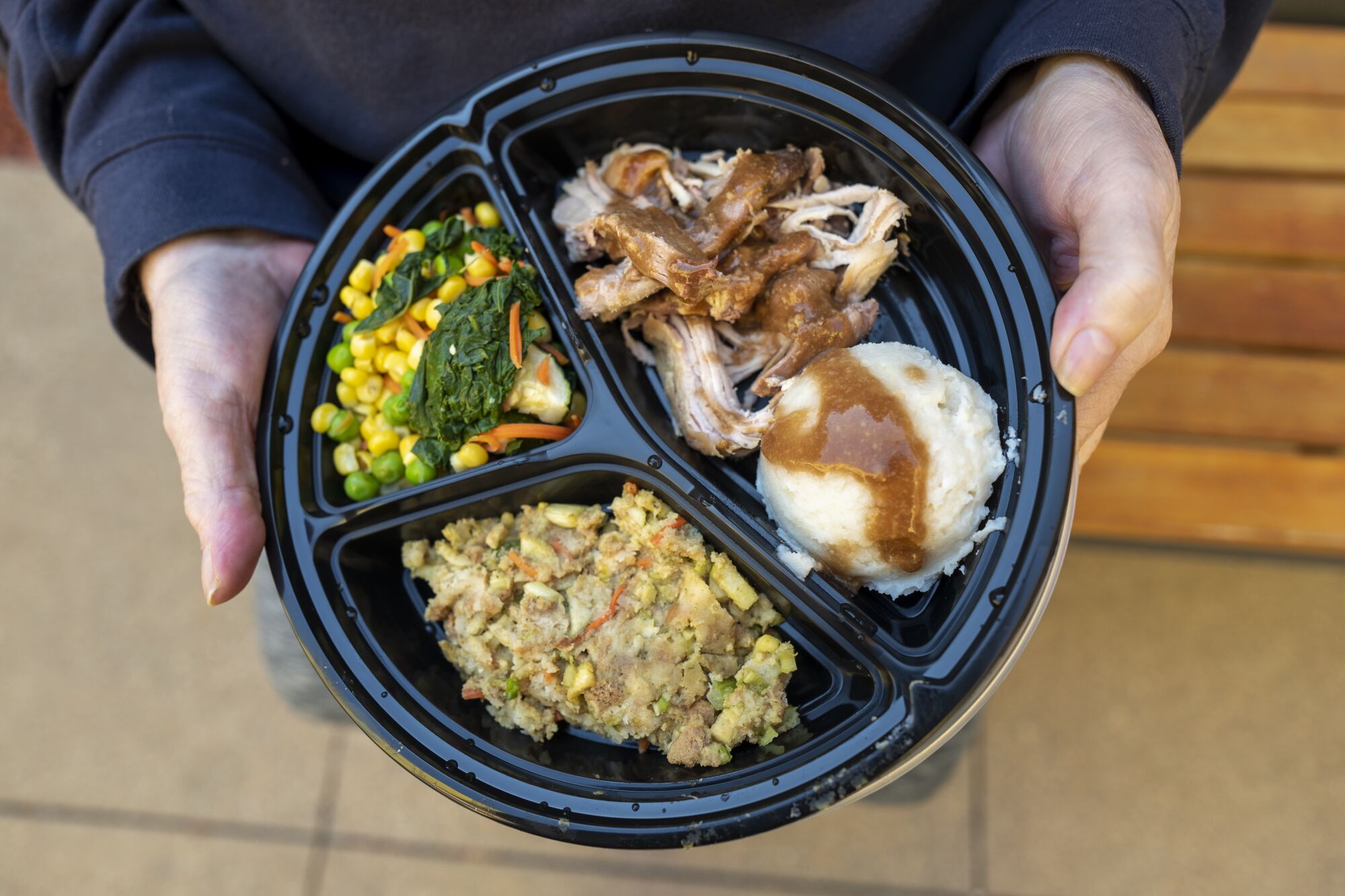 A woman holds a Thanksgiving meal.