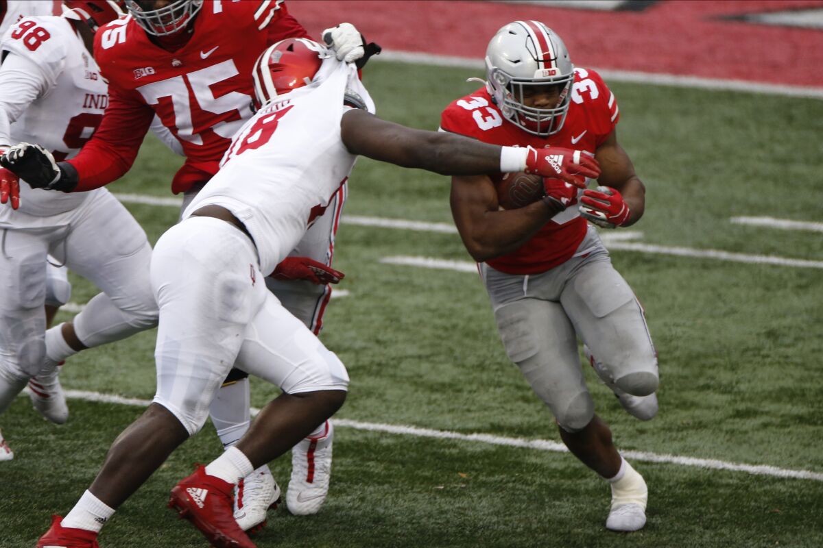 Ohio State running back Master Teague, right, cuts up field as Indiana defensive lineman Jonathan King tries to make the tackle during the second half of an NCAA college football game Saturday, Nov. 21, 2020, in Columbus, Ohio. Ohio State beat Indiana 42-35. (AP Photo/Jay LaPrete)