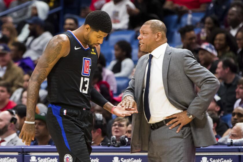 Los Angeles Clippers forward Paul George (13) taps the hand of Clippers head coach Doc Rivers as he walks to the bench in the second half of an NBA basketball game against the New Orleans Pelicans in New Orleans, Thursday, Nov. 14, 2019. (AP Photo/Sophia Germer)
