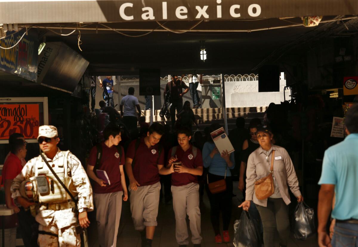 Arriba: Al final del día escolar, estudiantes de Calexico Mission School, con uniformes escolares, cruzan la frontera hacia Mexicali, México, donde viven. Abajo, izquierda: El alumno de último año Jorge Noriega, de 17 años de edad, regresa a casa en Mexicali, después de clases. Abajo, derecha: Después de la escuela, Jorge Noriega, alumno de Calexico Mission School, come algo mientras su madre, Brenda Gallardo, de 38, arregla el cabello de su hija en su hogar de Mexicali, México.