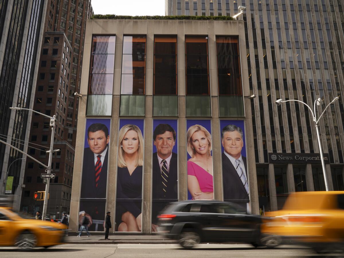 Images of Fox News personalities on the front of the News Corp. offices in New York City.