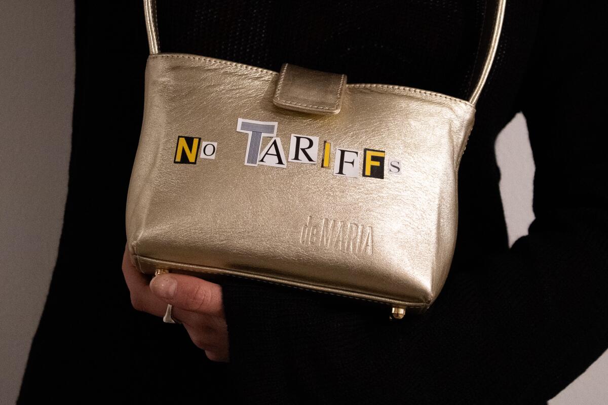 A gold-colored handbag with the words 'no tariffs'