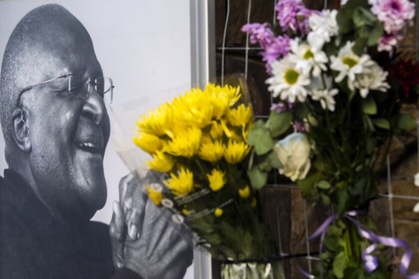 Flowers are placed alongside a photo of Anglican Archbishop Desmond Tutu at the St. George's Cathedral in Cape Town, South Africa, Sunday, Dec. 26, 2021. South Africa's president says Tutu, South Africa's Nobel Peace Prize-winning activist for racial justice and LGBT rights and the retired Anglican Archbishop of Cape Town, has died at the age of 90. (AP Photo)