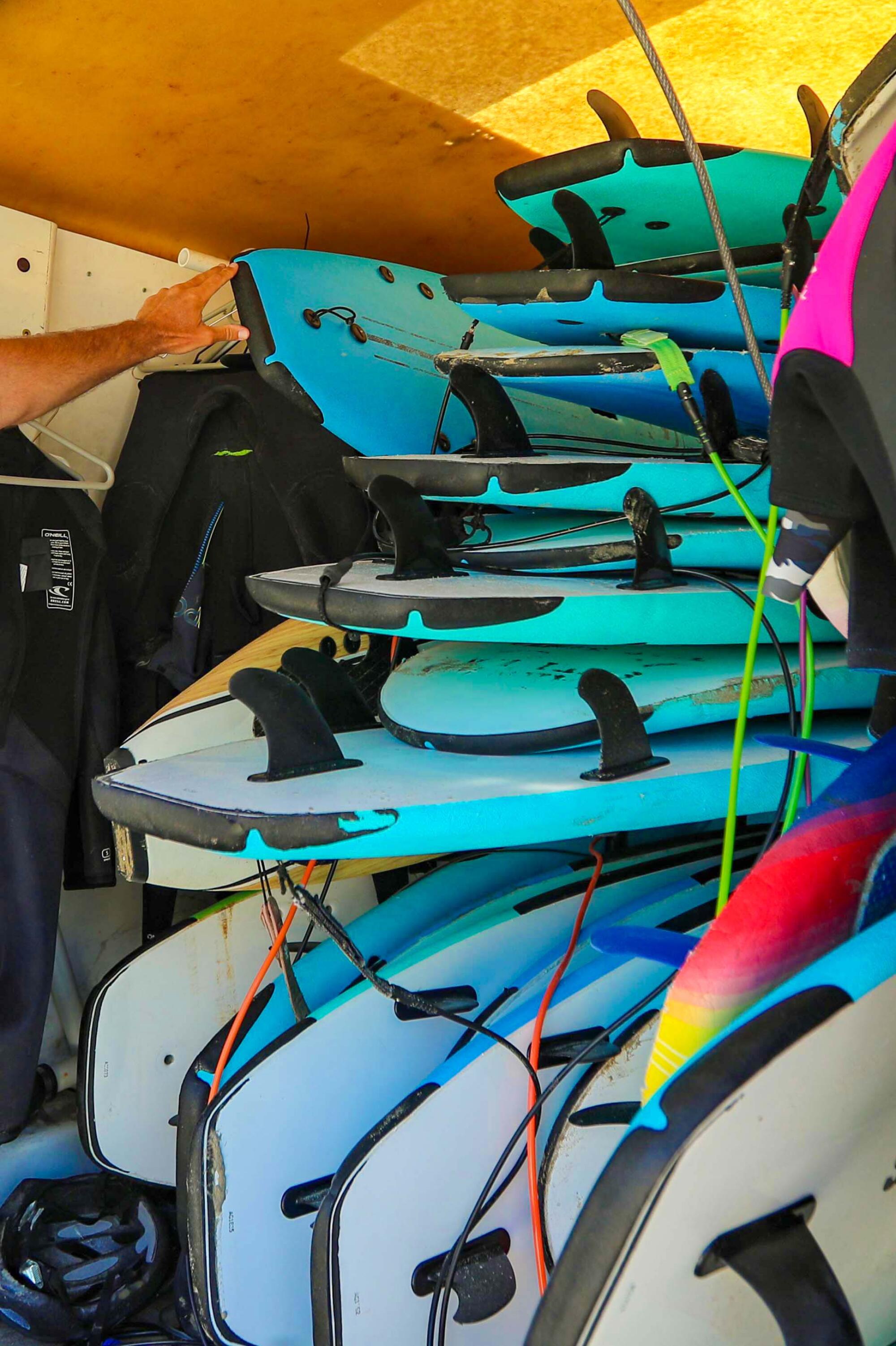 A stack of soft-top surfboards