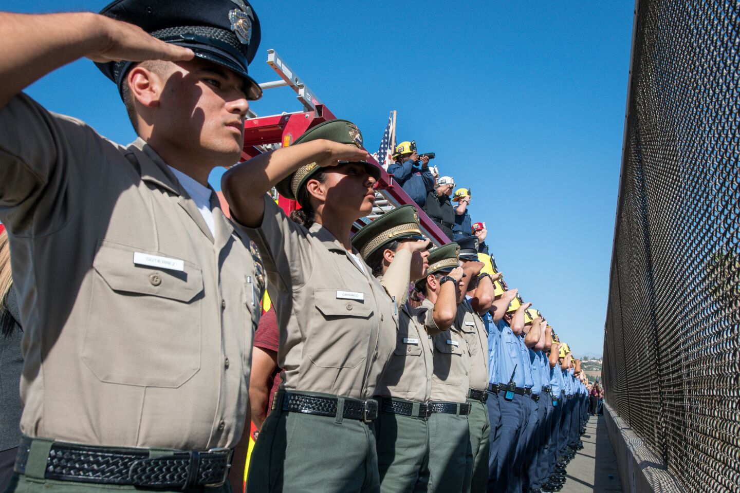Ventura County sheriff's cadets and Oxnard College Fire Academy cadets salute as the procession carrying the body of Sgt. Ron Helus heads to the medical examiner's office in Ventura.
