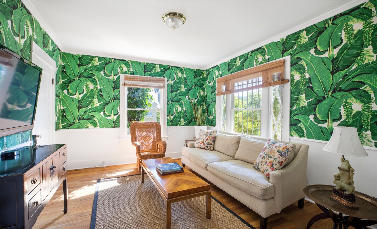 Deep green leaves cover the family room wallpaper.