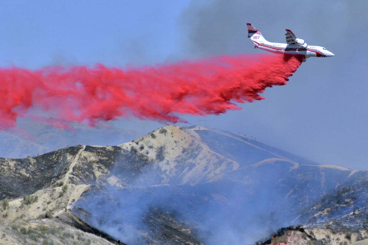 FILE - In this April 28, 2021, file photo, a fixed-wing tanker makes a drop of fire retardant on the North Fire in Castaic, Calif. By aggressively responding to smaller fire, officials said Thursday, May 13, 2021, they hope to minimize the number of larger fires that have become more common as climate change makes the landscape warmer and dryer (Dan Watson/The Santa Clarita Valley Signal via AP, File)
