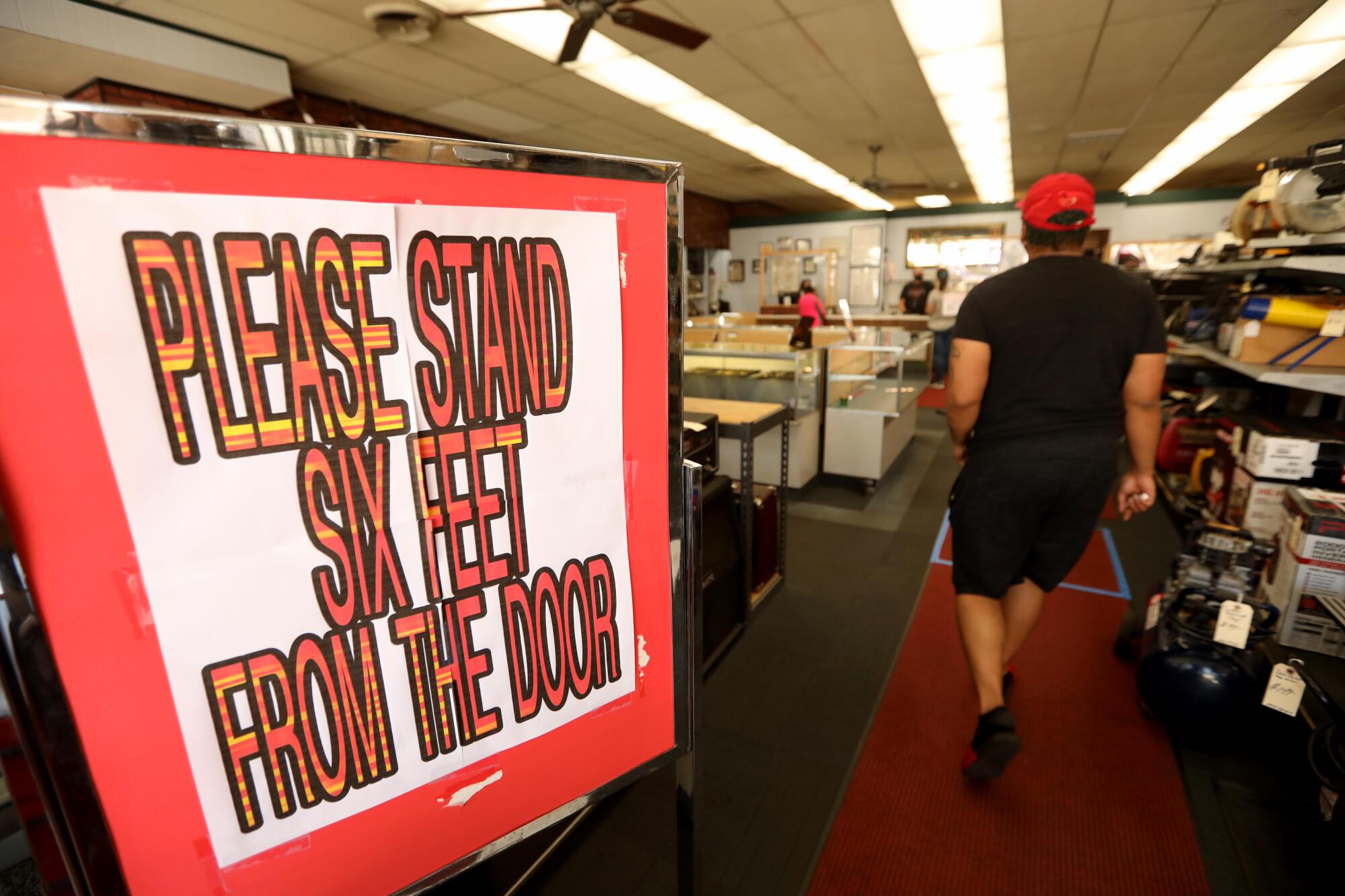 Social distancing signage greets customers at The Pawn Shop in downtown Atwater.