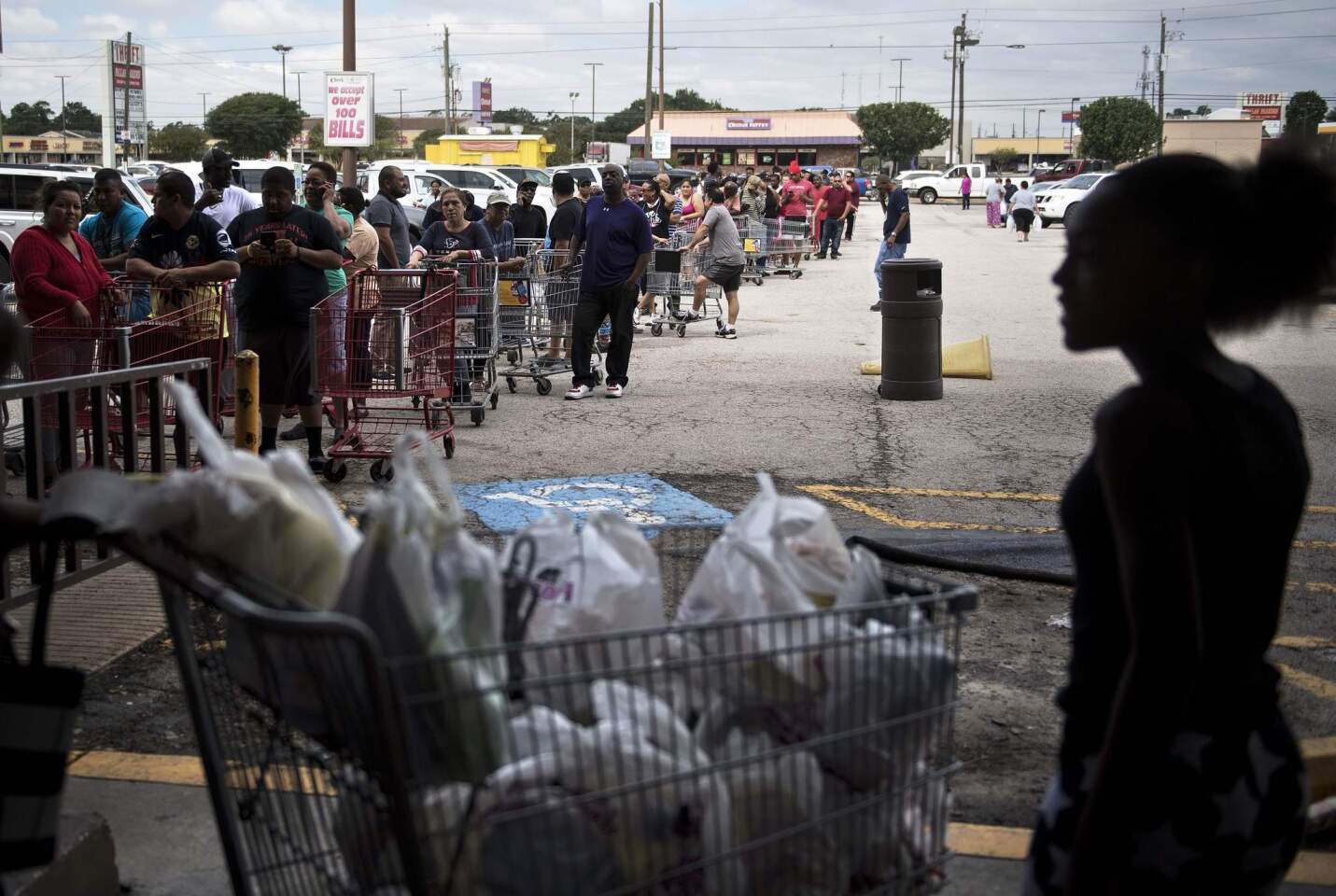 People wait in line to buy groceries at a Food Town during the aftermath of Tropical Storm Harvey.