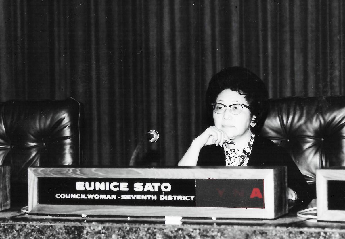 Eunice Sato sits at her desk.