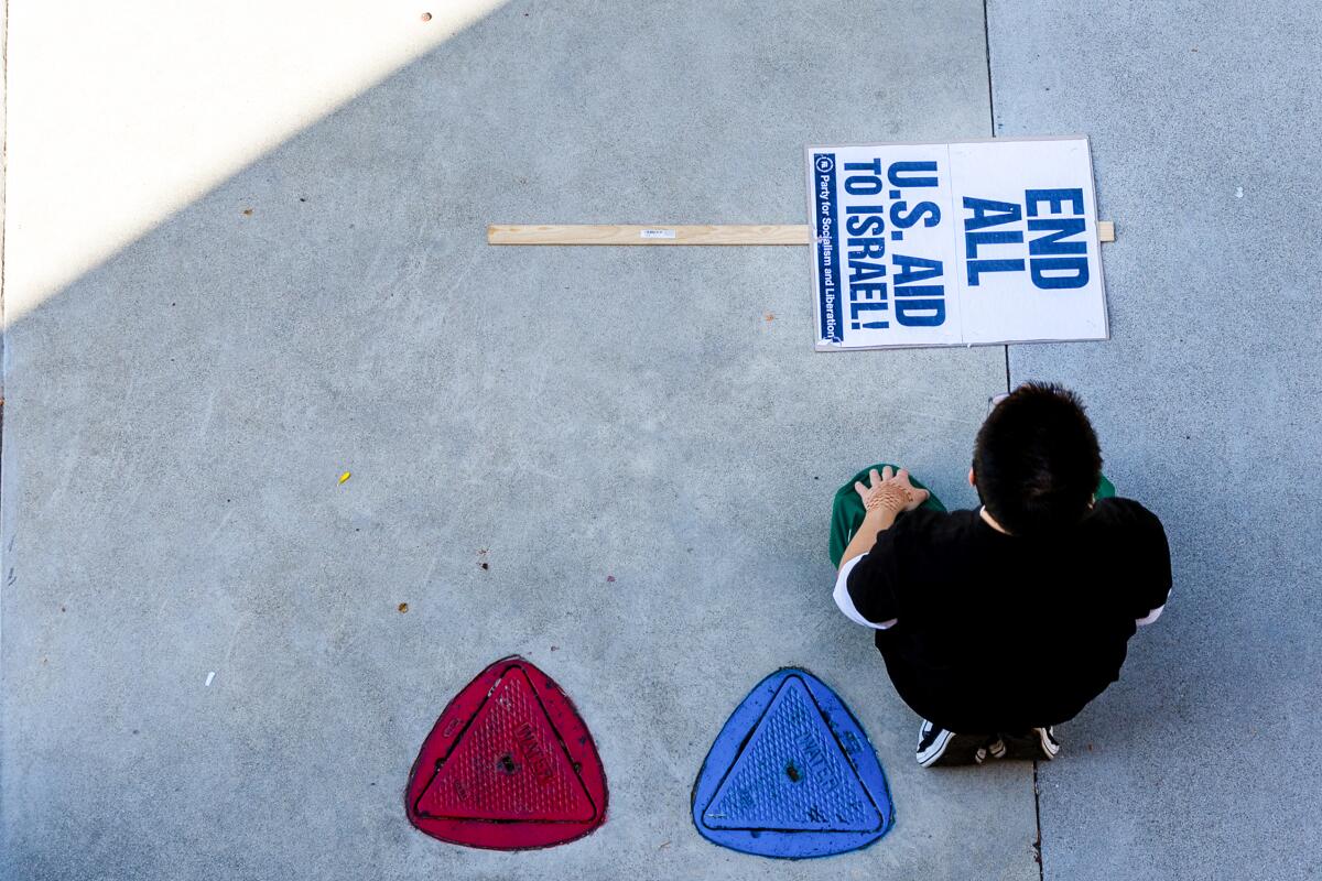 A protester uses an anti-Israel sign as a mat for afternoon prayers.