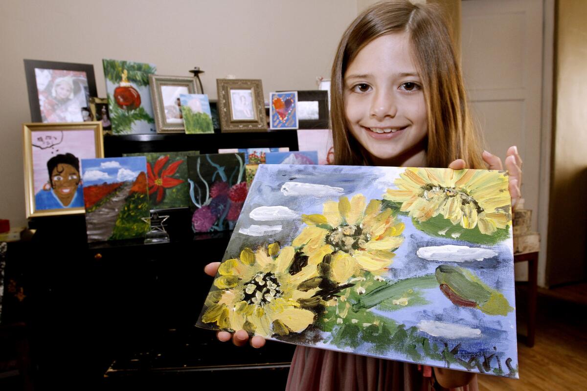 Artist Karis Zavala shows her top-10 finalist painting of sunflowers, at her home in Glendale on Wednesday, August 7, 2013. The eight-year old has been painting for two years and also was chosen as a winner in another competition.