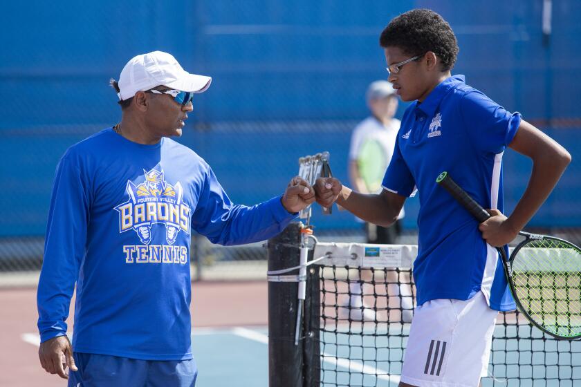 Fountain Valley High coach Harshul Patel, left, gives Malik Thiaw a fist-bump during the first round of the CIF Southern Section Division 1 playoffs against Beverly Hills at home on Wednesday.