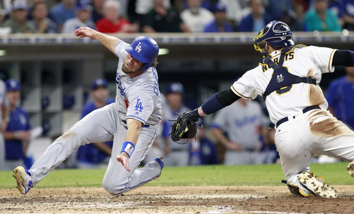 Dodgers shortstop Charlie Culberson dives around the tag attempt of Padres catcher Derek Norris to score a run in the sixth inning.
