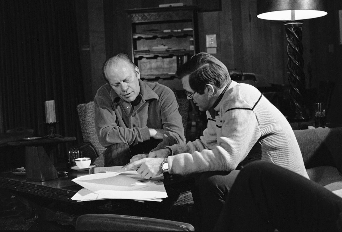 FILE - In this Dec. 24, 1974, file photo, President Gerald Ford and presidential assistant Donald Rumsfeld huddle over bills during work session in Vail, Colo. The president was spending a working holiday at the ski resort with his family. Rumsfeld, the two-time defense secretary and one-time presidential candidate, died Tuesday, June 29, 2021. He was 88. (AP Photo, File)
