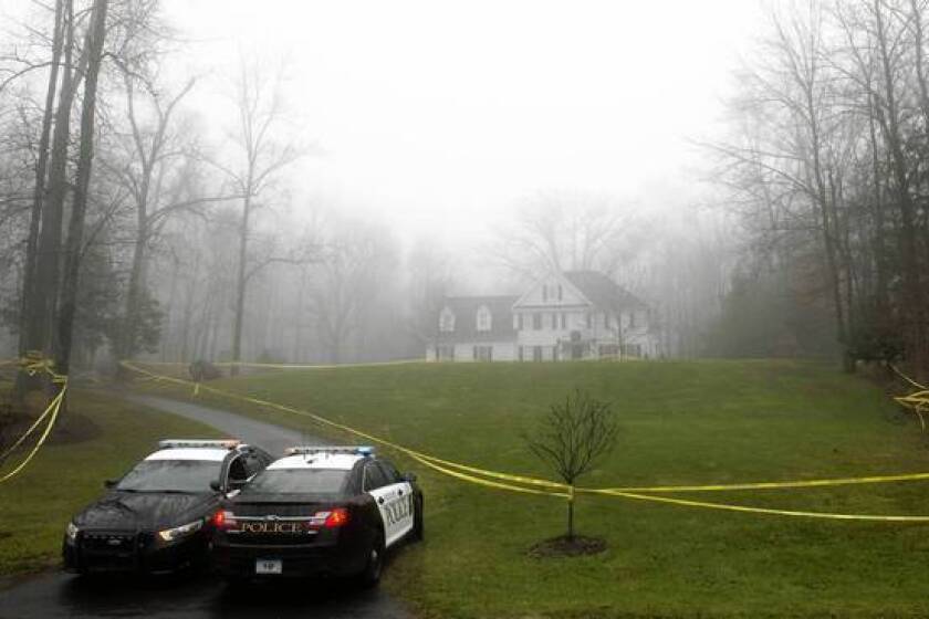 Police cordon off the home of Adam Lanza and his mother in December after the Newtown, Conn., school massacre. Search warrants show he had assembled an arsenal of guns, knives and ammunition.