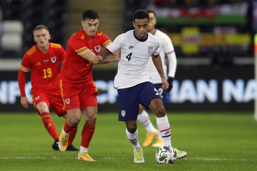 United States' Tyler Adams, right, controls the ball as Wales' Tom Lawrence holds him during the international friendly soccer match between Wales and USA at Liberty stadium in Swansea, Wales, Thursday, Nov. 12, 2020. (AP Photo/Kirsty Wigglesworth)