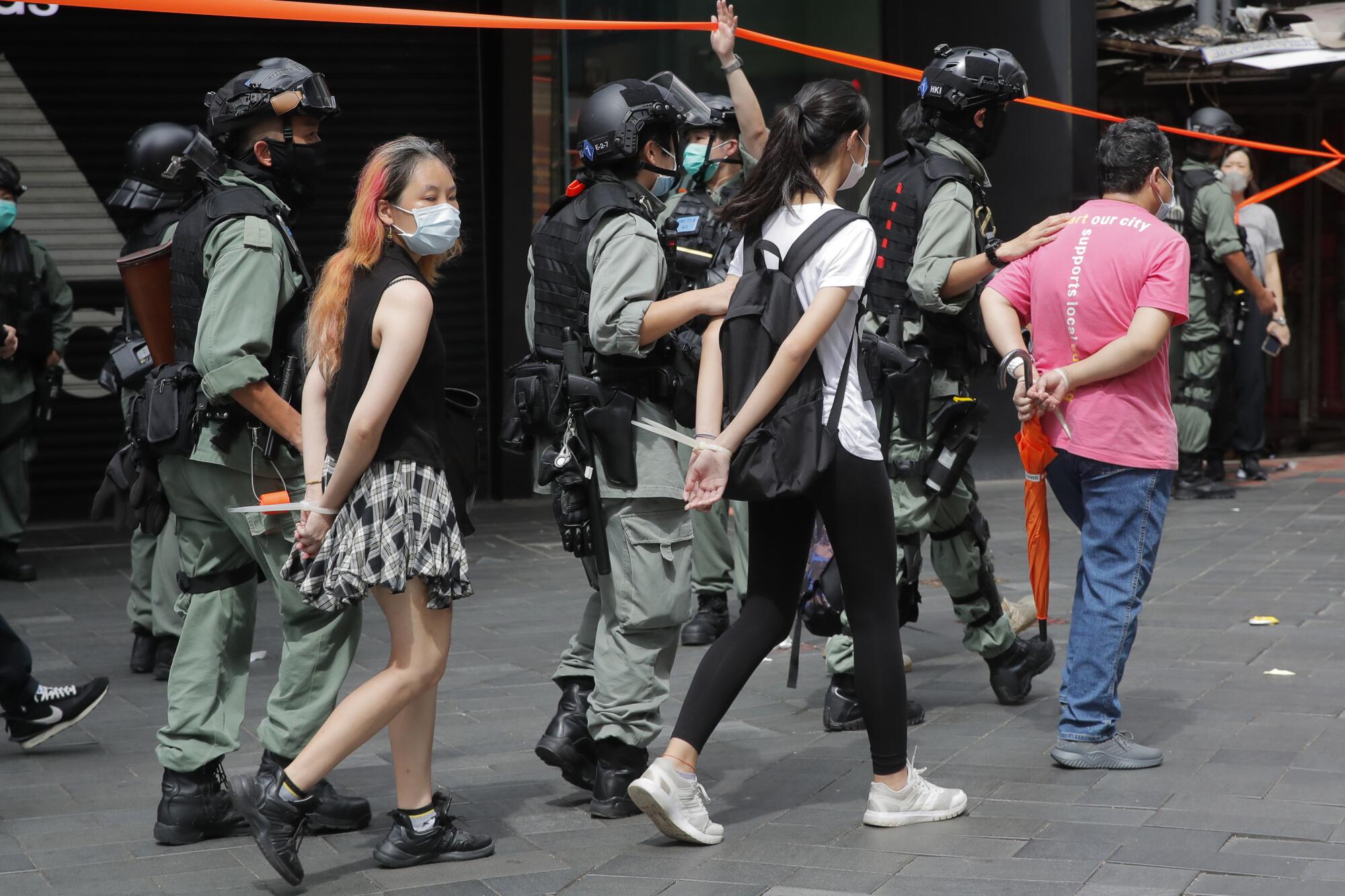 Hong Kong police detain security law protesters in Causeway Bay on Wednesday.