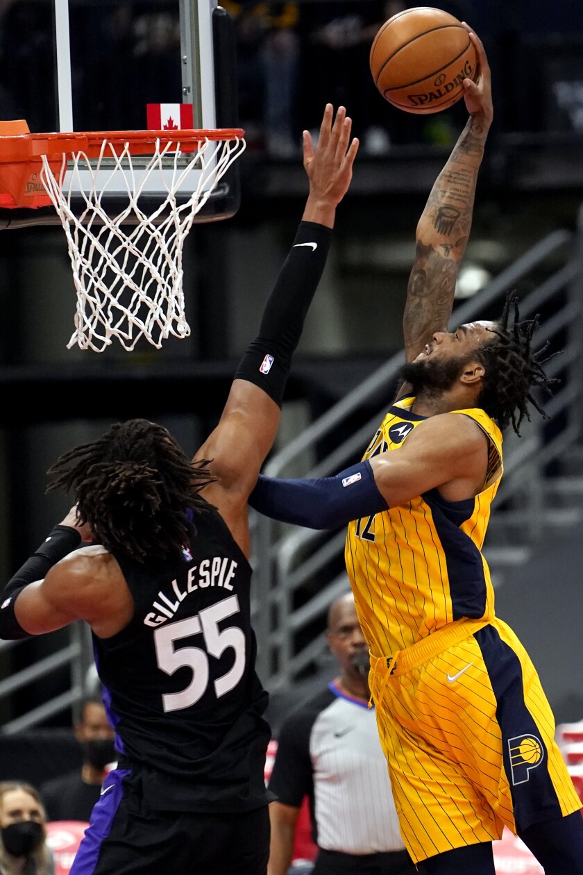 Indiana Pacers forward Oshae Brissett (12) goes up for a slam dunk in front of Toronto Raptors forward Freddie Gillespie (55) during the second half of an NBA basketball game Sunday, May 16, 2021, in Tampa, Fla. (AP Photo/Chris O'Meara)