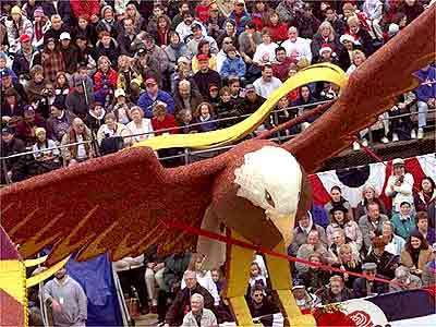 American Eagle appears to fly over crowd as "Together We Rise Above" float by Panda Express.