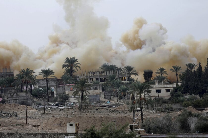 In this Nov. 4 photo, smoke rises from explosions demolishing houses on the Egyptian side of the border town of Rafah. The Egyptian army is doubling the size of a buffer zone along the Gaza border, an operation that will involve the destruction of about 1,200 homes, military officials said.