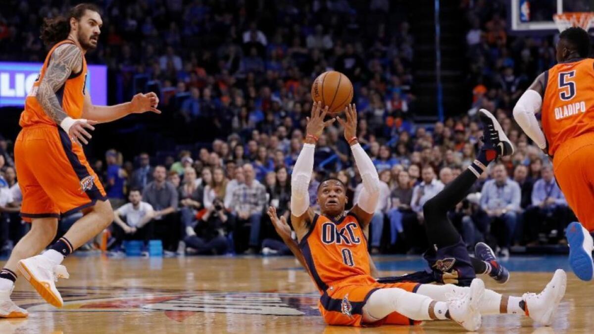 Thunder guard Russell Westbrook (0) flips a pass over his head to Oklahoma City center Steven Adams (12) during a game against the New Orleans Pelicans on Dec. 4.