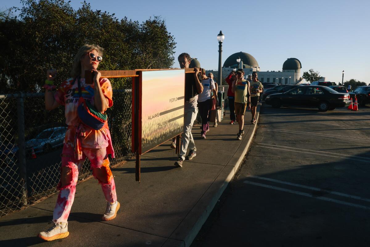 Lauren Powell guides a group of art goers through a parking lot.