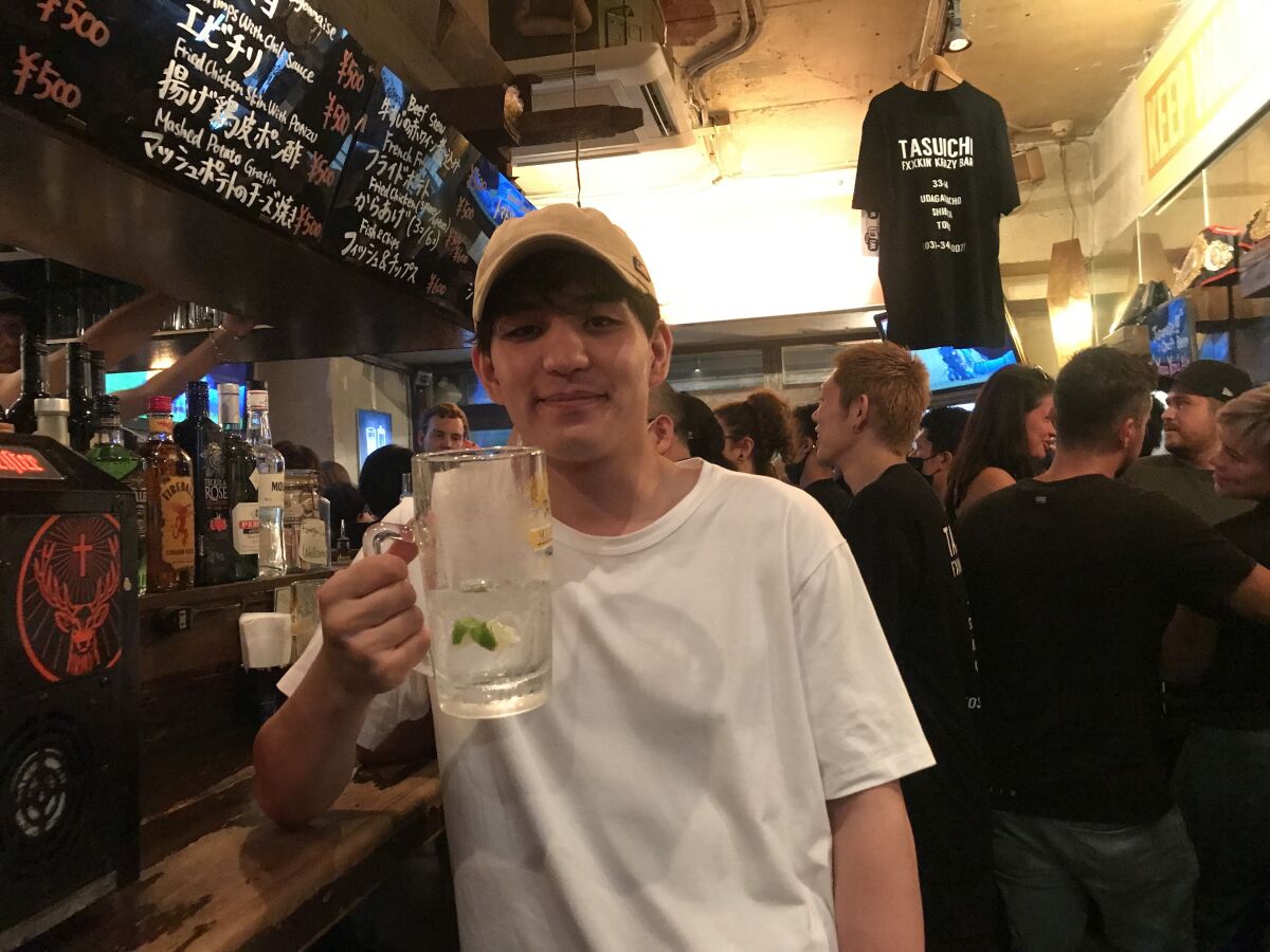 Yuto Saiki, 24, is well into his 2-pint glass of gin and tonic at a crowded Tokyo bar defying the state of emergency.