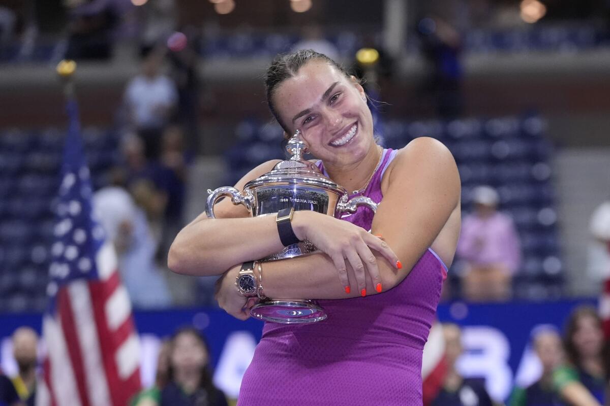 Aryna Sabalenka celebrates with the U.S. Open winner's trophy after defeating Jessica Pegula.