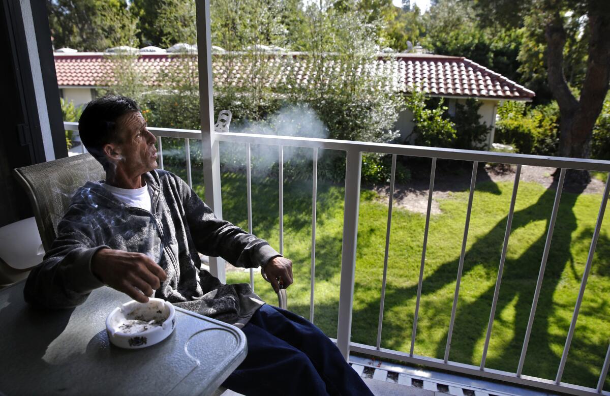 On the porch of his Laguna Woods home, Robert Evans, 52, who has cancer, smokes a medical marijuana cigarette. When he uses pot, he vomits less frequently.