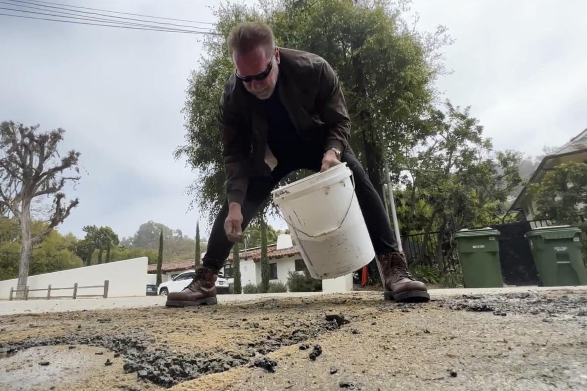 Arnold Schwarzenegger repairs a pothole in his Brentwood neighborhood.