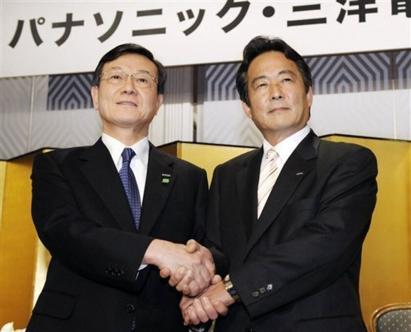 In this Nov. 7, 2008 file photo, Panasonic Corp. President Fumio Ohtsubo, left, and Sanyo Electric Co. President Seiichiro Sano shake hands prior to their joint press conference in Osaka, western Japan. When Panasonic's acquisition of smaller Japanese rival Sanyo is completed, forming one of the world's biggest electronics makers, global consumers are likely in for little visible change in products lining store shelves _ at least for some time. (AP Photo/Kyodo News, File)