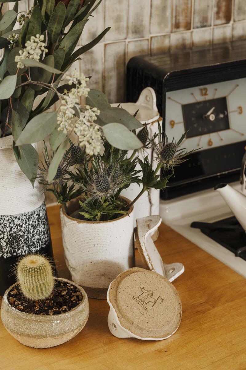 Ceramics and flower pots next to a stove in the kitchen.