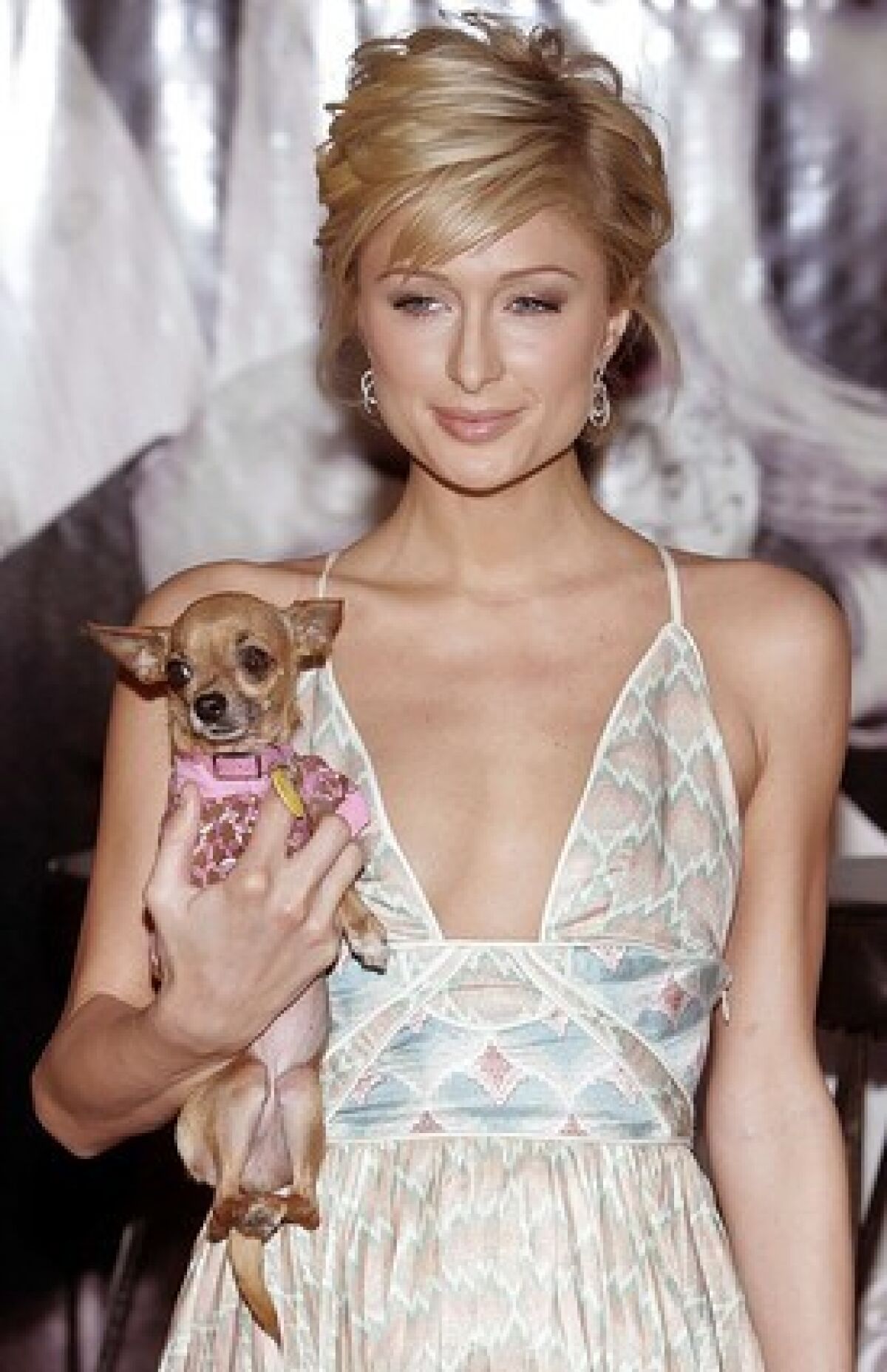 Paris Hilton, holding her chihuahua Tinkerbell in one hand