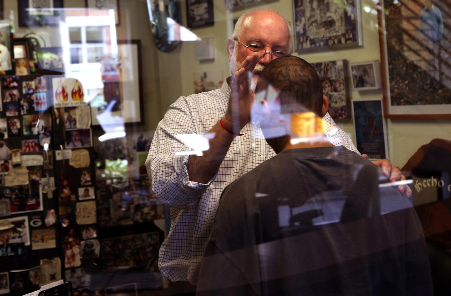 Father Gregory Boyle, founder and director of Homeboy Industries, prays over Rolando Motta, 26, in his office. Boyle created Homeboy Industries to assist high-risk youth.