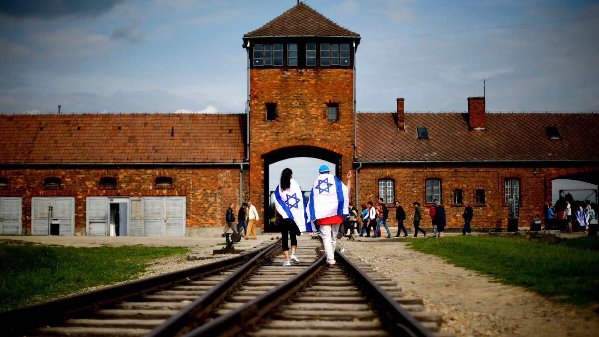 Visitors walk on railway tracks on the grounds of the former Nazi death camp Auschwitz-Birkenau near Oswieciem, Poland, in June 2015.