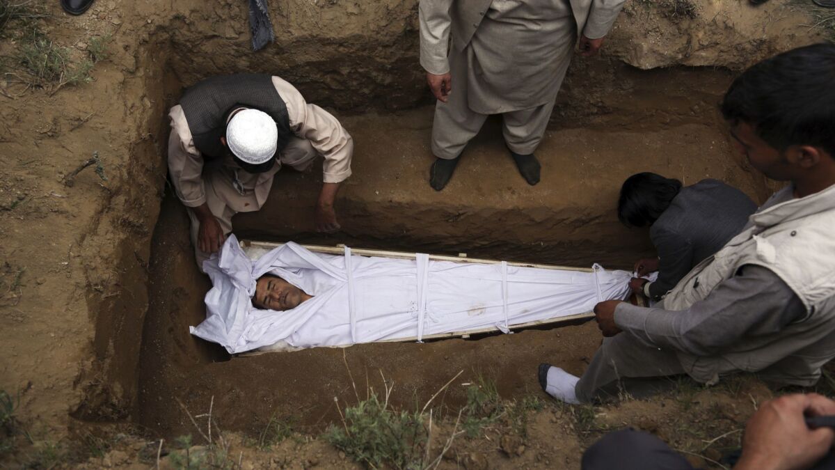 Relatives, colleagues and friends bury AFP chief photographer Shah Marai, who was among those killed in the Kabul attacks on April 30, 2018.