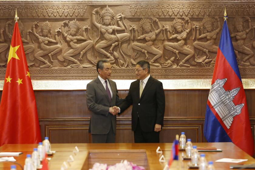 In this photo released by Agence Kampuchea Press (AKP), Chinese Foreign Minister Wang Yi, left, greets with Cambodia's Foreign Minister, SOK Chenda Sophea, right, in Phnom Penh, Cambodia, Sunday, April 21, 2024. Wang Yi, arrived Cambodia to mark his 3 days official visit (21-23 April) Cambodia to reaffirm his country's commitment and to boost the already firmly tied to southeast Asian country, twice visited in the last eight months. (AKP via AP)