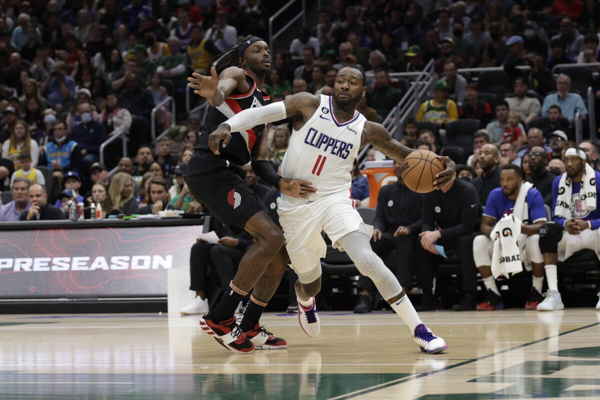 Clippers guard John Wall drives past Trail Blazers forward Jerami Grant.