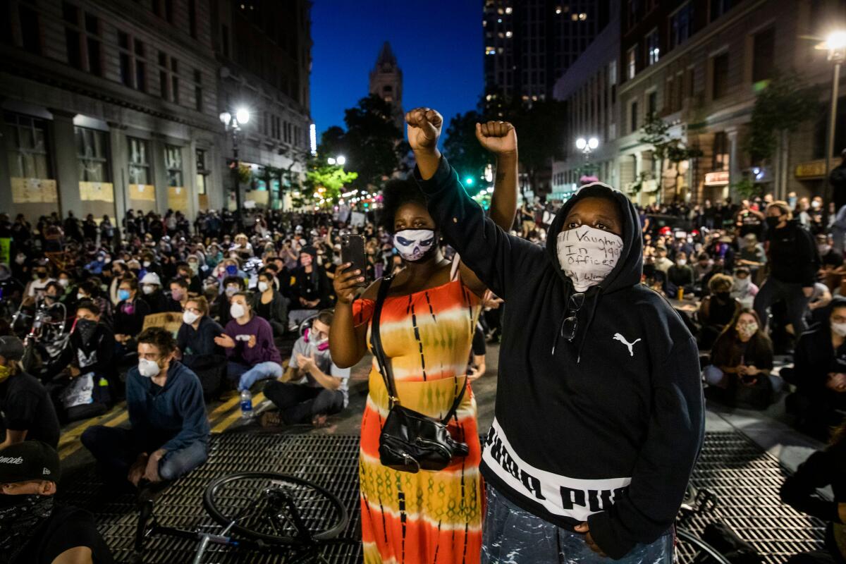 Demonstrators raise their fists during a "Sit Out the Curfew" protest in Oakland on Wednesday.