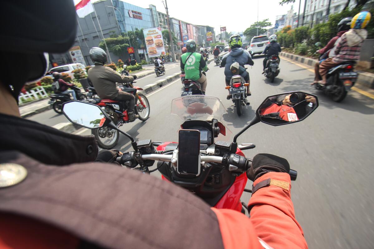 A motorcyclist rides while following others on their motorbikes. 