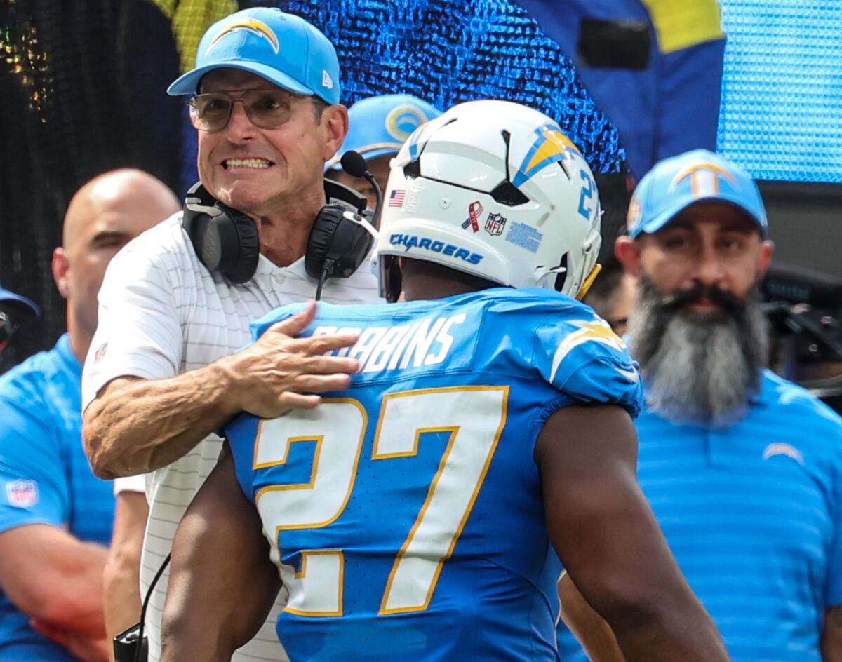 Chargers coach Jim Harbaugh congratulates J.K. Dobbins after the running back scored a touchdown.