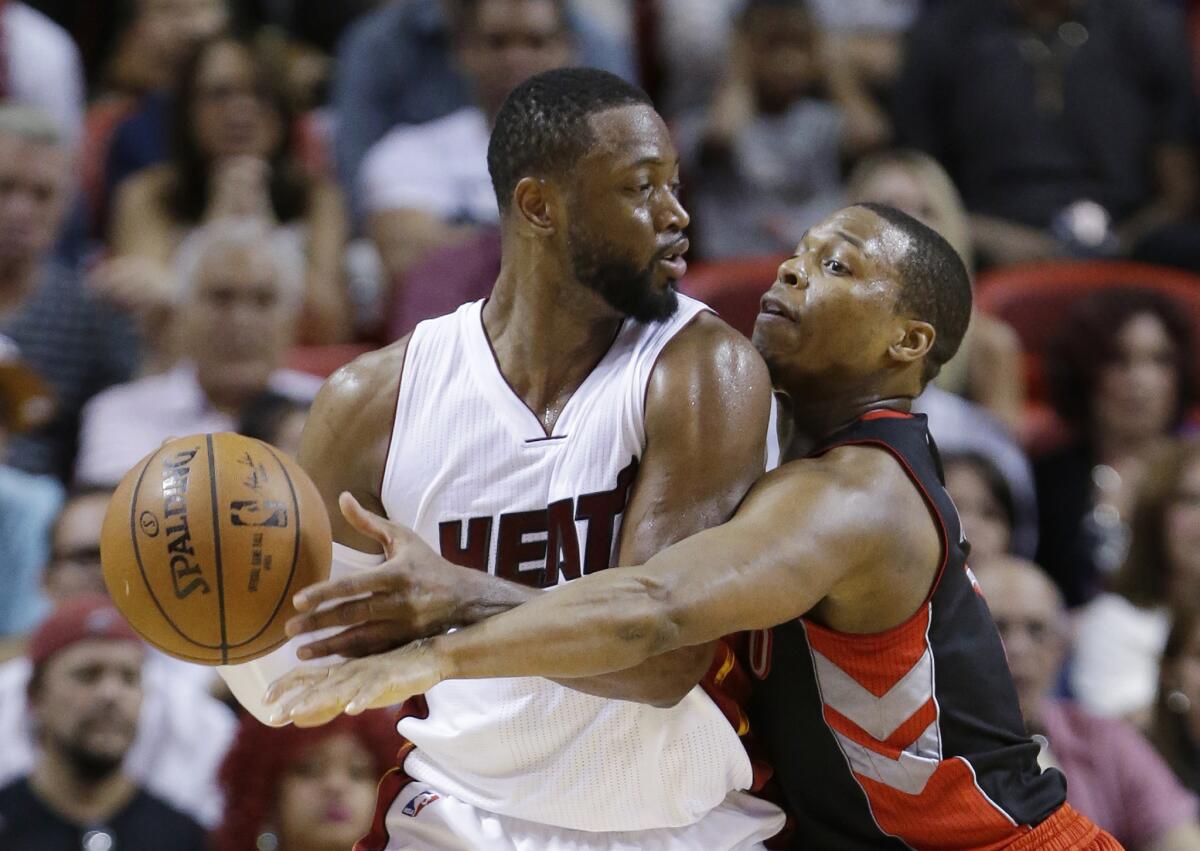 Miami Heat guard Dwyane Wade is defended by Toronto Raptors guard Kyle Lowry on April 11.