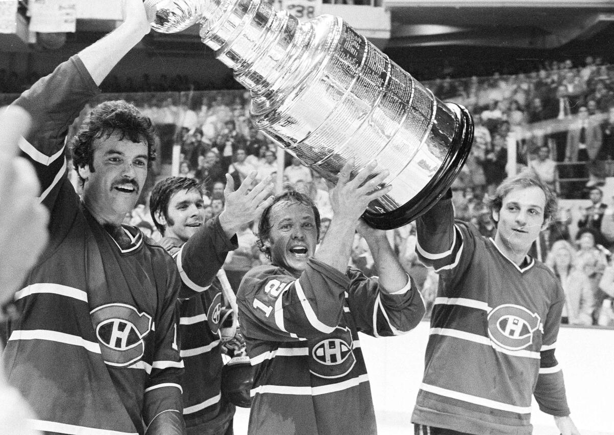 Montreal Canadiens captain Yvan Cournoyer, center, carries the Stanley Cup with teammates.