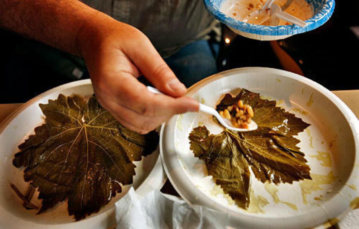 Making dolmas (stuffed grape leaves). Click here for the recipe.