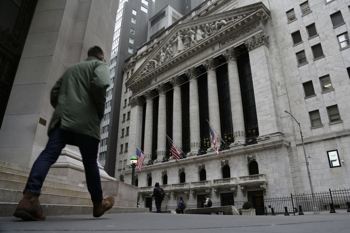 People walk by the front of the New York Stock Exchange. 