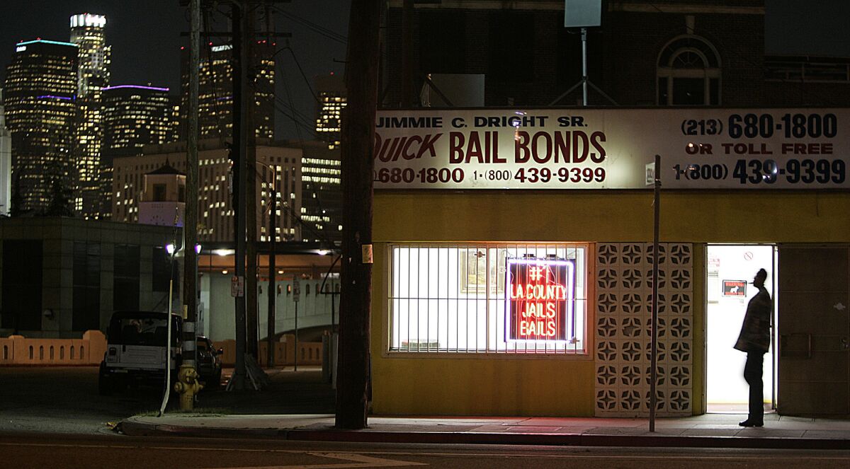 The lights of downtown Los Angeles shine behind the Quick Bail Bonds building.