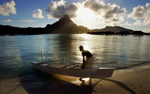 A paddler maneuvers his outrigger canoe into the water near the InterContinental as the sun sets behind Mt. Otemanu. Author James Michener dubbed Bora-Bora's lagoon "the most beautiful in the world." Michener, stationed here during World War II, is said to have used the island as one of the models for the mythical Bali Hai in his book "Tales of the South Pacific."