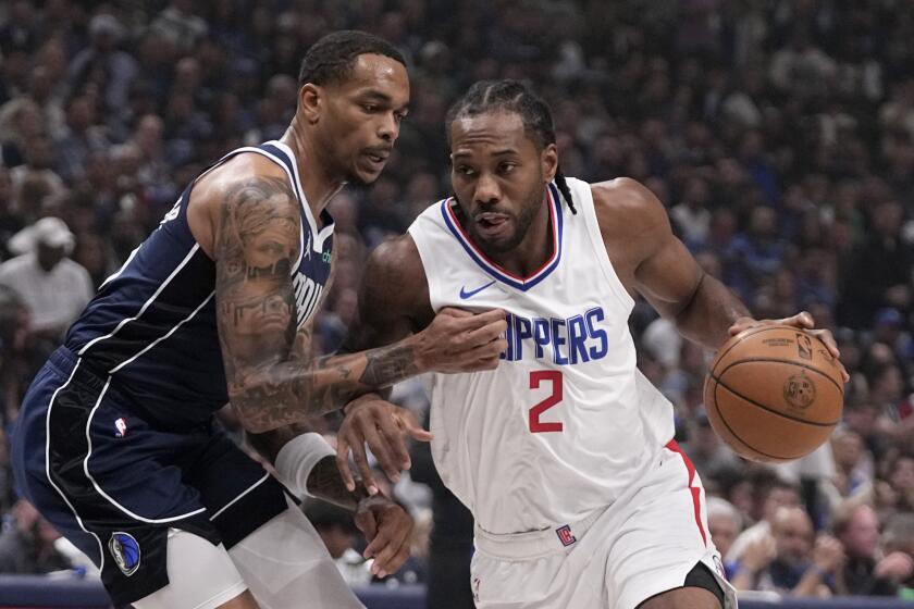 Dallas Mavericks forward P.J. Washington, left, defends as Los Angeles Clippers' Kawhi Leonard.